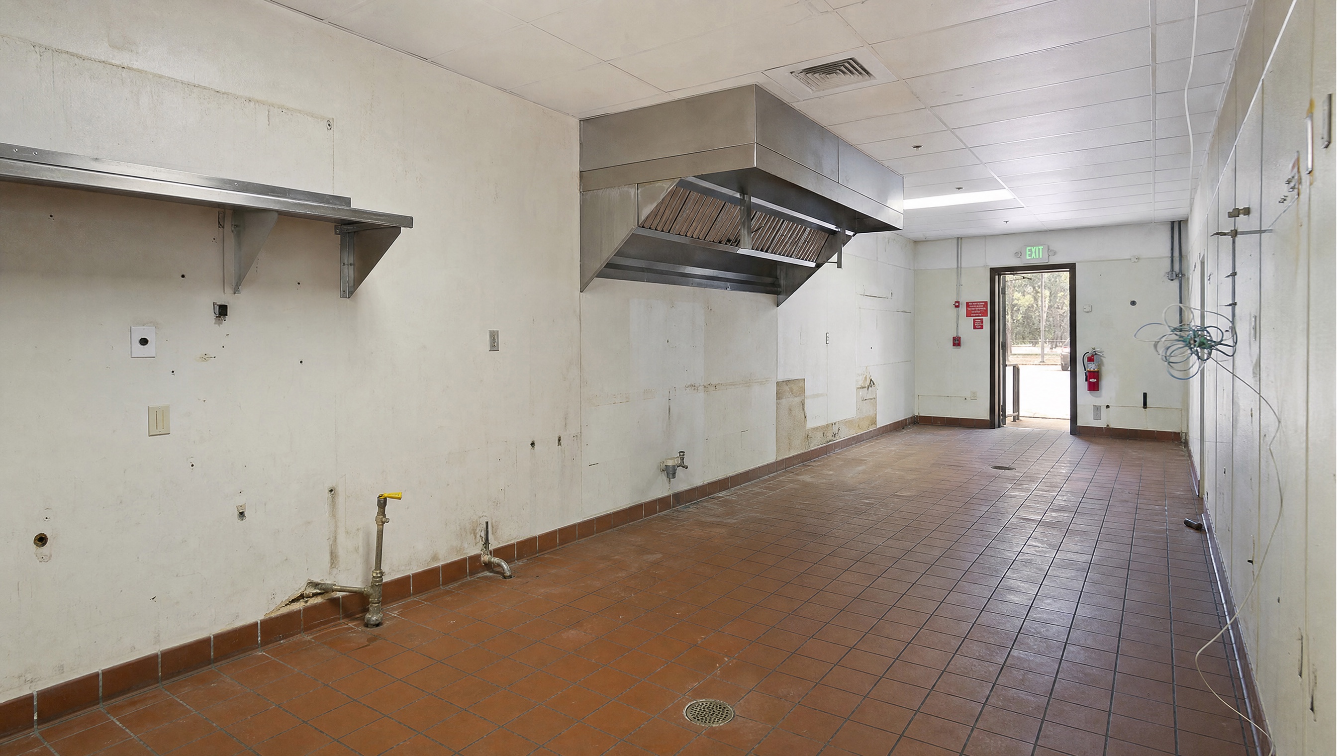 Existing 12' Type I hood over the former cook line. Roof curb and penetration are reusable.